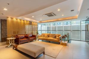 a living room with two couches and a table at Hotel Laghetto Moinhos in Porto Alegre