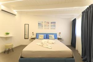 a bedroom with a large bed with blue accents at B&Suite Le Meraviglie in Terrasini