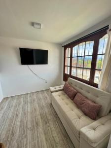 a living room with a couch and a flat screen tv at Sofi House Zap in Zapatoca