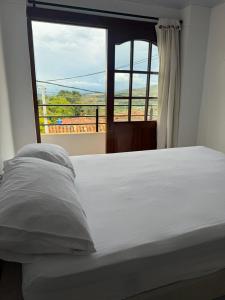a bed in a room with a large window at Sofi House Zap in Zapatoca