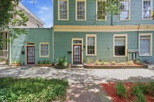 a green house with a driveway in front of it at Walk to it All in Downtown, Double King Beds in Savannah
