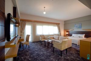 a hotel room with a bed and a couch and chairs at KTÜ Koru Otel in Trabzon