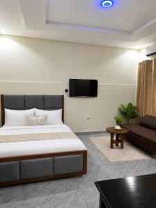 a bedroom with a large bed and a couch at Ecostar apartments in Morogoro +21 photos