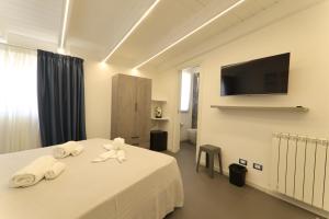 a hotel room with a bed with towels and a tv at B&Suite Le Meraviglie in Terrasini