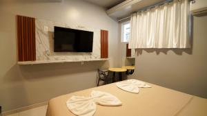 a room with a bed and a tv on a wall at Barrudada Palace Hotel-Boa Vista in Boa Vista