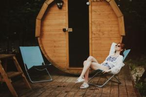 a woman sitting in a chair in front of a sauna at Chata Ignasia in Stronie Śląskie
