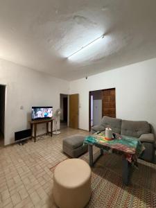 a living room with a couch and a table and a tv at L'Urbain in Ziguinchor