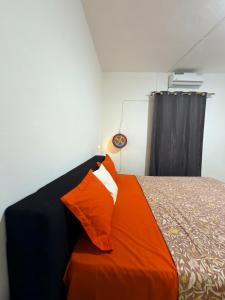 a bedroom with a bed with an orange blanket at L'Urbain in Ziguinchor +1 photo