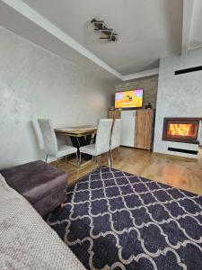 a living room with a dining room table and a fireplace at Domek na Sosnowej in Wilków