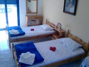 twee bedden in een slaapkamer met twee rode bloemen erop bij Horizon View Studios in Amoopi