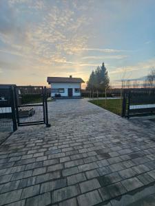 a brick driveway with a building in the background at Domek na Sosnowej in Wilków +9 photos