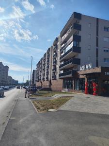 an asian apartment building on the side of a street at Apartman A&V in Vranješ