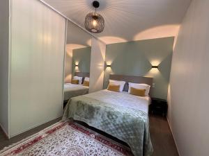 a small bedroom with two beds and a mirror at Bel Appartement Perrières in Brive-la-Gaillarde