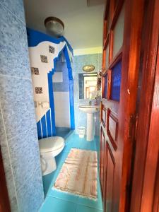 a blue bathroom with a toilet and a sink at Dar Sababa in Chefchaouen