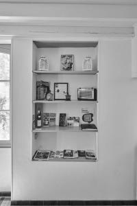 a shelf in a kitchen with books on it at Gîte ferme équestre avec piscine in Castex