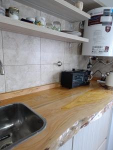 a kitchen counter with a sink and a microwave at Amaicha Luján in Luján +8 photos