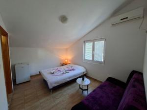 a small bedroom with a bed and a couch at Mia in Glavatske Kućice