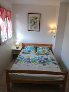 a bedroom with a bed with a floral bedspread at La Salamandre in Fouras