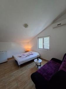 a bedroom with a bed and a couch at Mia in Glavatske Kućice