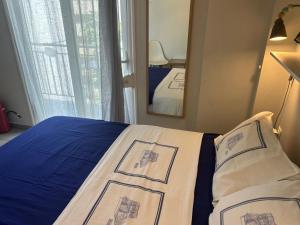 a bedroom with a bed with blue sheets and a mirror at Royal Zea Suite 3 in Piraeus