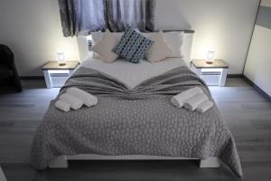 a bedroom with a large bed with two night stands at North Pearl Guesthouse in Porto Moniz