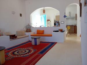 a living room with a couch and a red rug at Dar El Amel in Mellita
