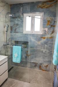a bathroom with a shower with a glass door at North Pearl Guesthouse in Porto Moniz +19 photos