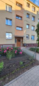 a building with pink flowers in front of it at Przy rynku in Olecko