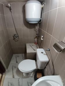 a small bathroom with a toilet and a sink at Rousan House in Um Qeis +26 photos