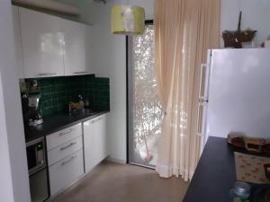 a kitchen with a white refrigerator and a window at Dream house steps from sea in Pídima Kyrás
