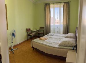 a bedroom with a bed and a table and a window at Guest House Lilia in Yerevan