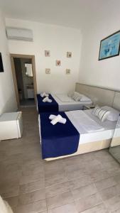 two beds in a hotel room with towels on them at orhan pansiyon in Çeşme +5 photos