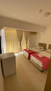 a room with two beds and a tv in it at orhan pansiyon in Çeşme