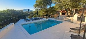a swimming pool with chairs next to a house at Villa JJ in Omiš