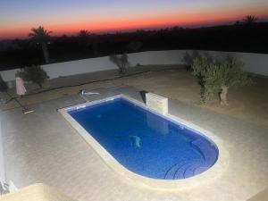a swimming pool in the middle of a yard at Dar El Amel in Mellita +10 photos