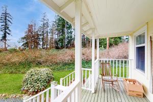a porch of a white house with two chairs at Cozy Cottage w/ Hot Tub in Freeland, Pets Welcome! in Freeland