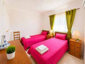 two beds in a room with pink sheets at Apartamento Oásis Parque 3 in Portimão +17 photos