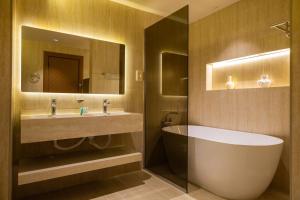 a bathroom with a tub and a sink and a mirror at شقق برج داماك جدة Damac Jeddah in Jeddah +71 photos