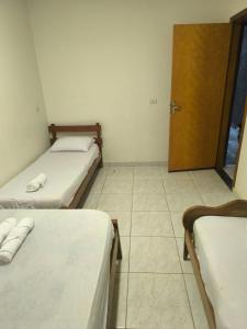 a small room with two beds and a door at Recanto sonho meu in Trindade