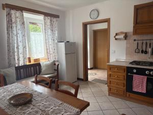 a kitchen with a table and a kitchen with a refrigerator at Apartma Suzy in Bovec