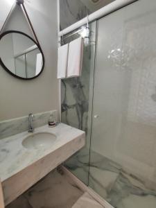 a bathroom with a sink and a glass shower at Guesthouse Villa Dourada in Rio de Janeiro