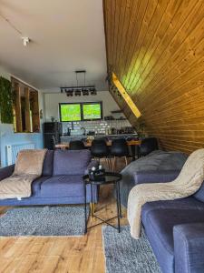 a living room with two purple couches and a table at A-frame Noa Cabin in Teşila