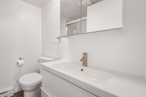 a white bathroom with a sink and a toilet at Unit 31 - 5 bedrooms, 8 people in Beaupré +12 photos