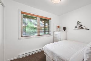 a white bedroom with a bed and a window at Unit 31 - 5 bedrooms, 8 people in Beaupré