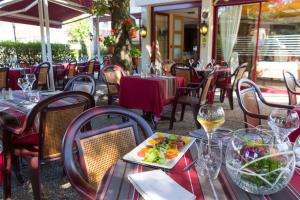 a restaurant with tables and chairs with a plate of food at Auberge de la Terrasse in Villersexel