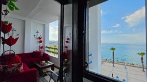 a living room with a red couch and a view of the ocean at Star beach in M'diq