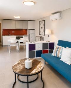 a living room with a blue couch and a table at Óros Residence - Pool & Panoramic Views in Tzíkidhes