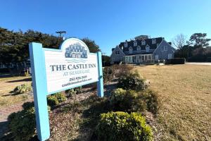 a sign in front of a house with a building at 08-Flight Suite at The Castle Inn in Ocracoke