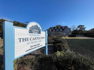 a sign in front of a house with a building at 07-Founders Suite at The Castle Inn in Ocracoke