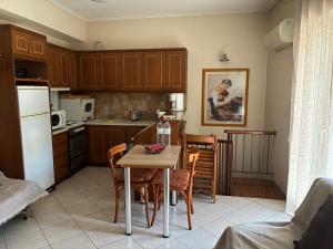 a kitchen with a table and chairs and a kitchen with a refrigerator at Basis Apartment in Karpenisi